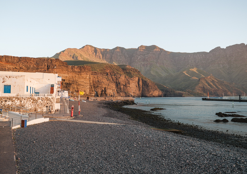 Bielone domy z niebieskimi detalami i wulkaniczna plaża w Puerto de las Nieves